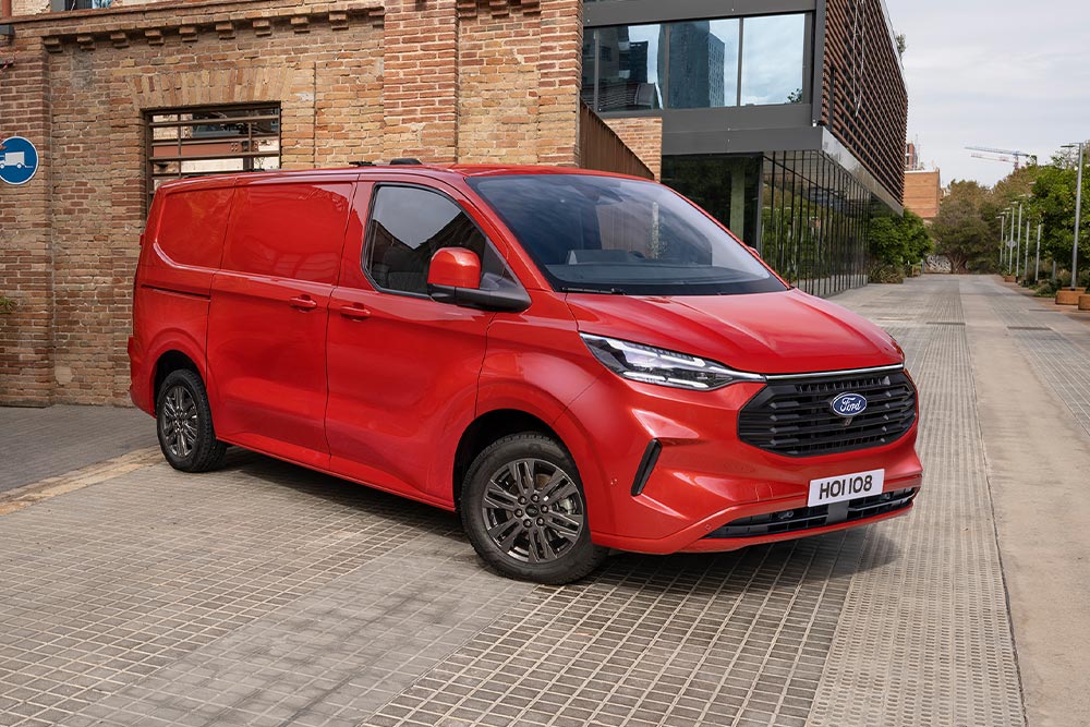 Red Ford Transit Custom van parked on a city street.