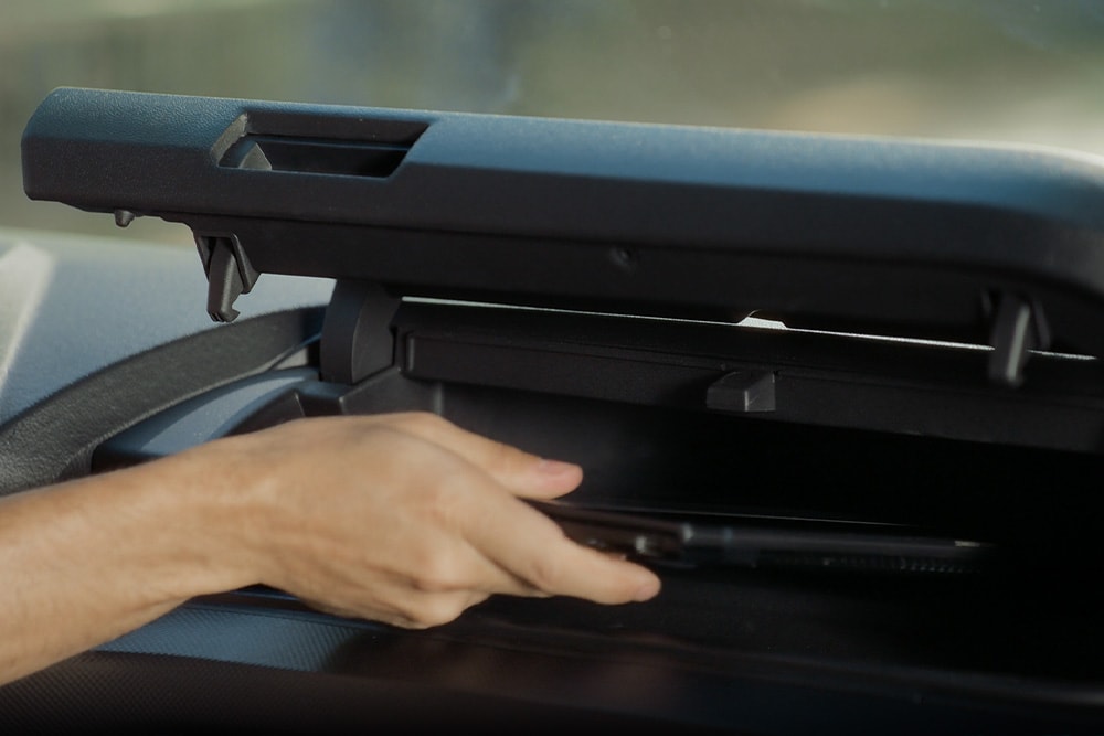 Hand opening a storage compartment in Ford Transit Custom.