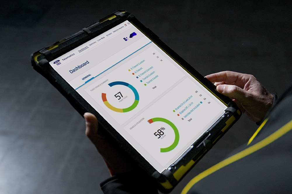 Person holding a tablet displaying Ford Pro vehicle data.
