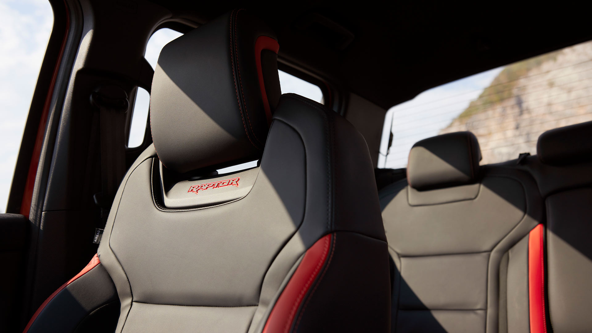 Black seats with Raptor logo and red details.