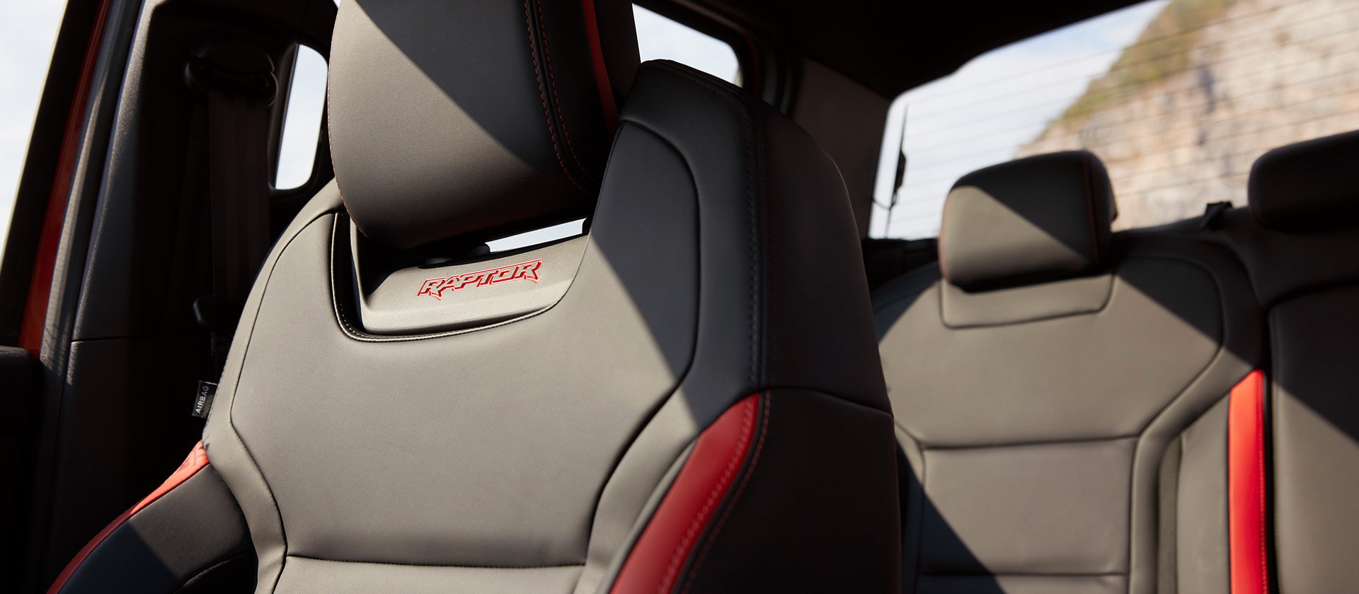 Black seats with Raptor logo and red details.