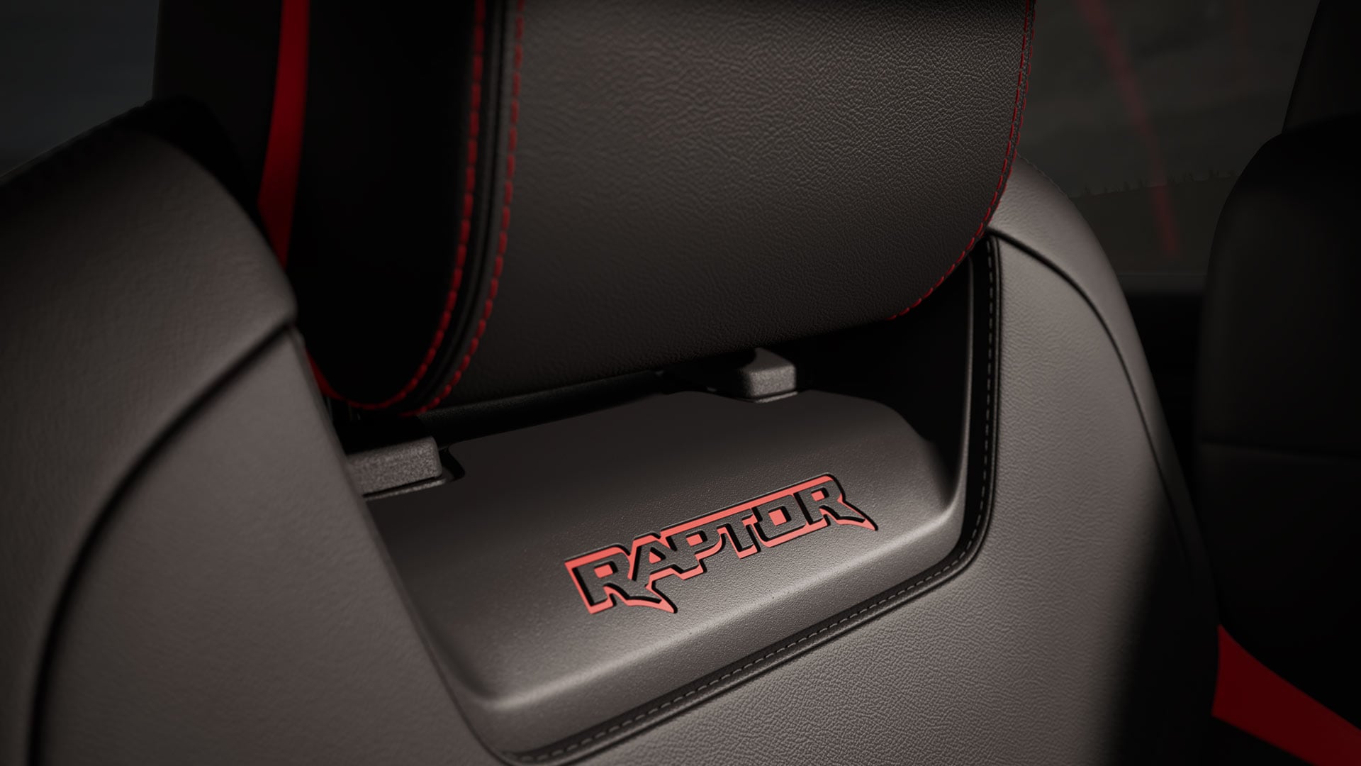 Close-up of red Raptor logo on a black seat.