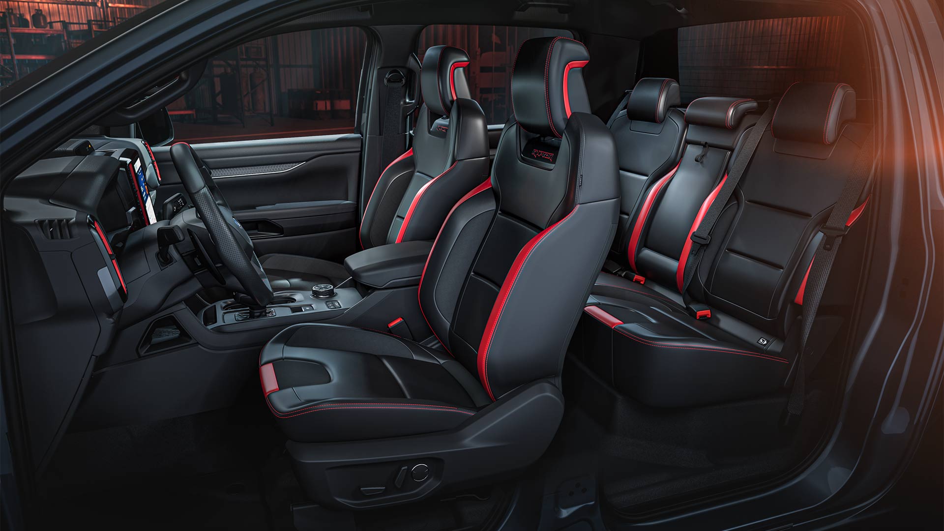 Interior view of a Ford Ranger Raptor, focusing on the vehicle's red-accented seats.