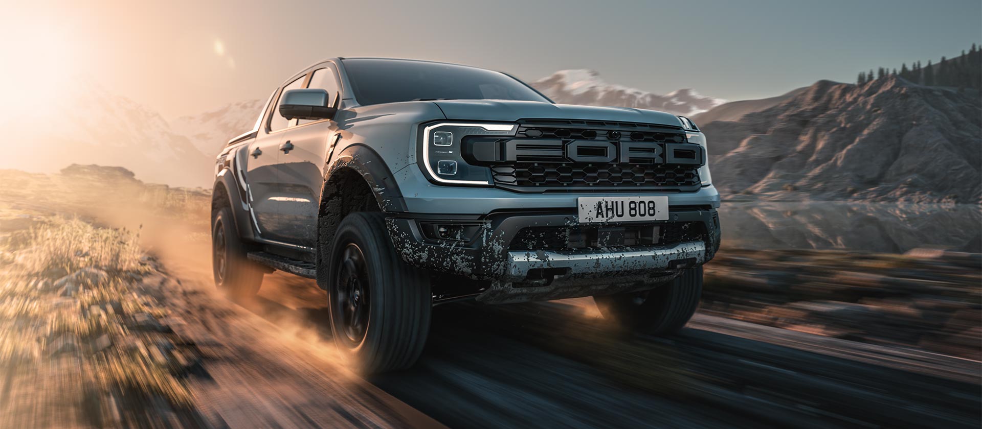 Ford Ranger Raptor driving through a dusty and dramatic landscape.