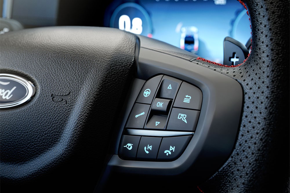 Close up of the Ranger Raptor's steering wheel, highlighting the vehicle's R button.