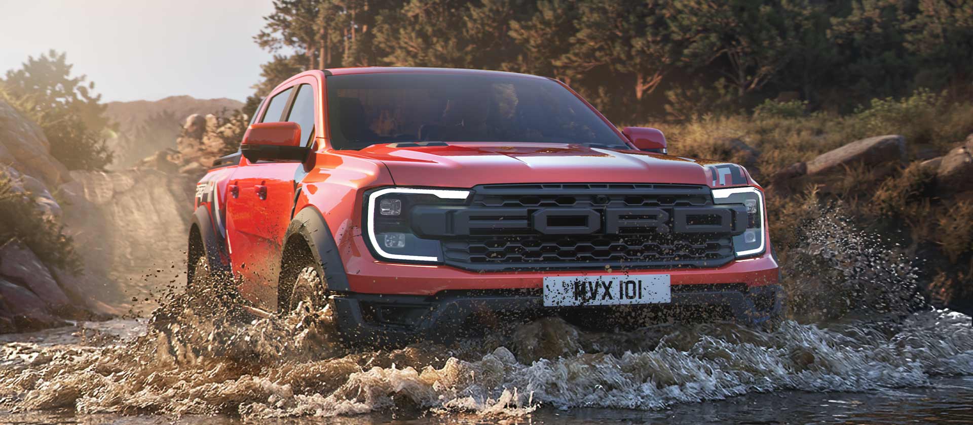 A red Ranger Raptor driving through muddy water, splashing around its wheels in an off-road setting.
