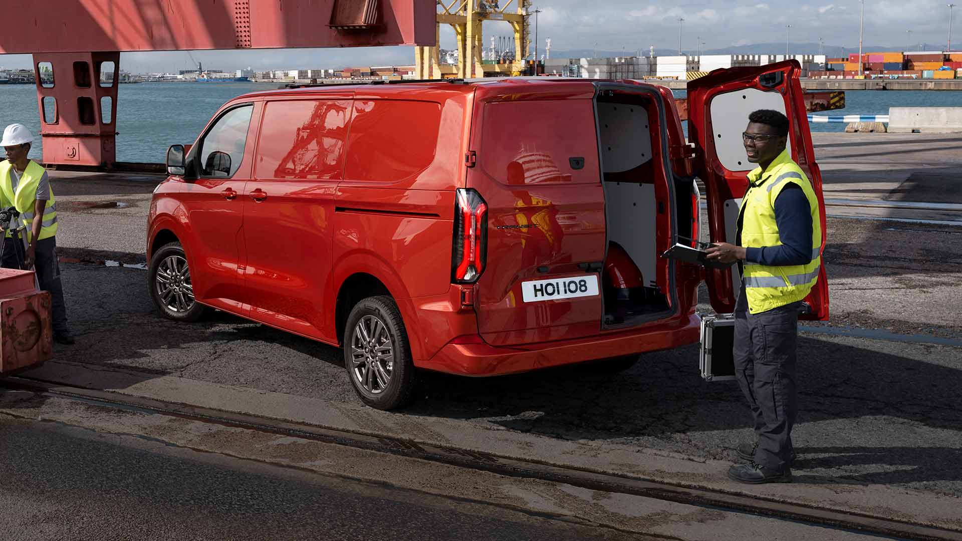 Red Ford Transit Custom van at a dock.
