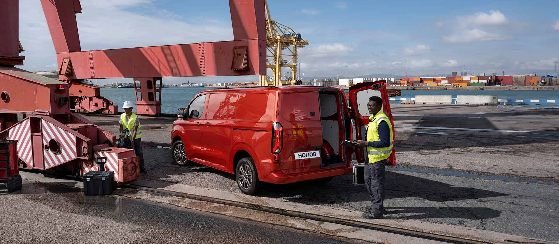Red Ford Transit Custom van at a dock.