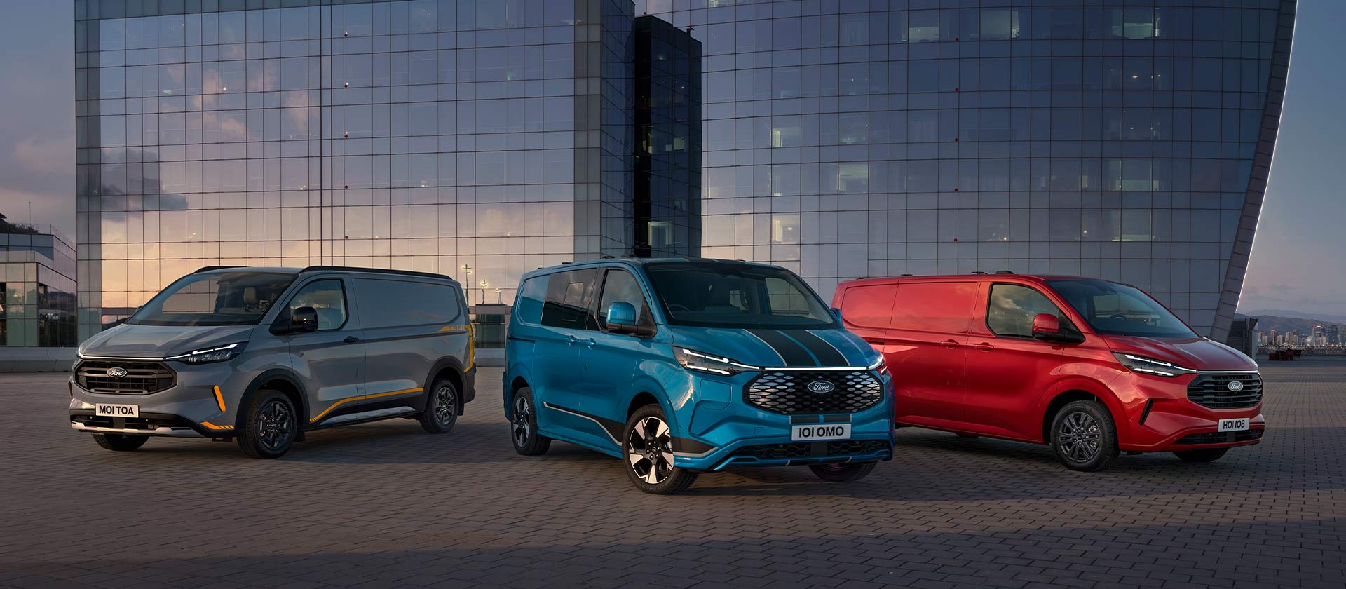 Three Ford Transit Custom Sport vans in grey, blue, and red parked. 