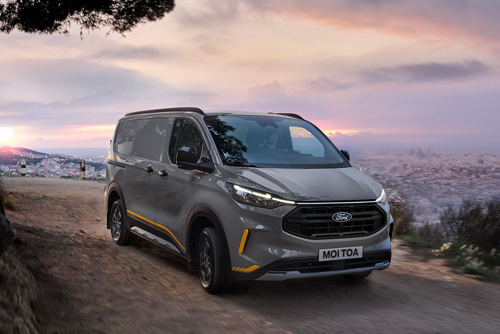 Grey Ford Transit Custom Trail van with yellow accents.