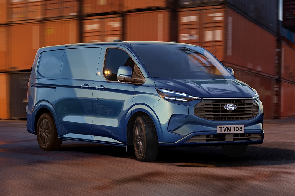 Blue Ford Transit Custom Plug-in Hybrid van drives through a dock yard.