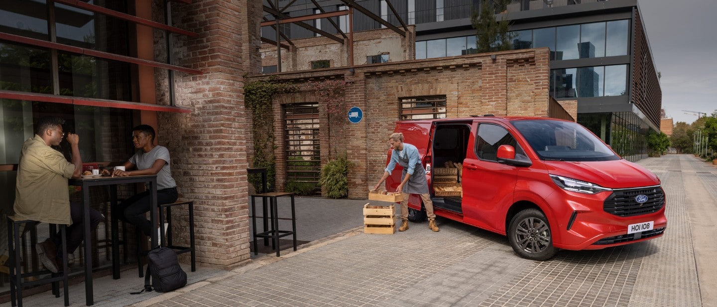 Red ford transit custom with a person making a delivery