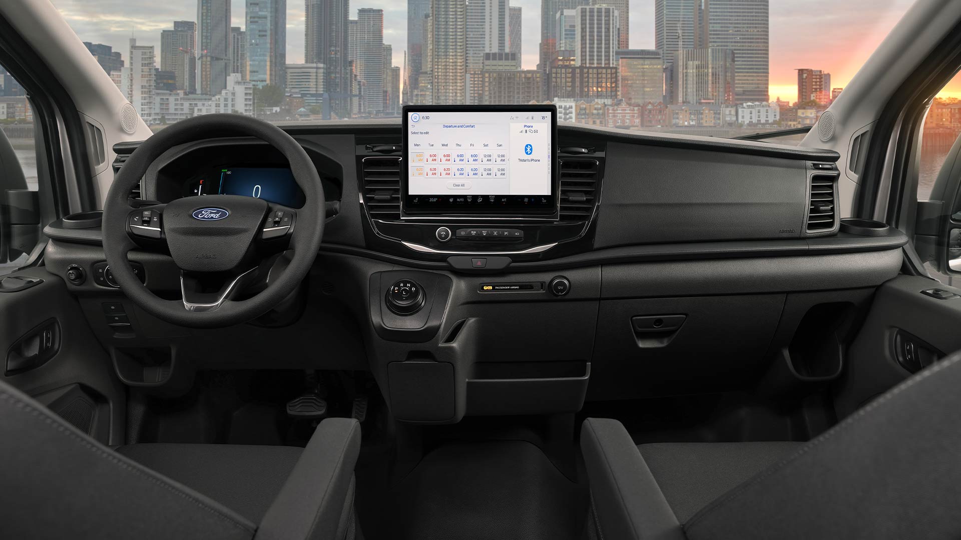 Interior view of a Ford E-Transit van's dashboard, steering wheel, and infotainment screen.