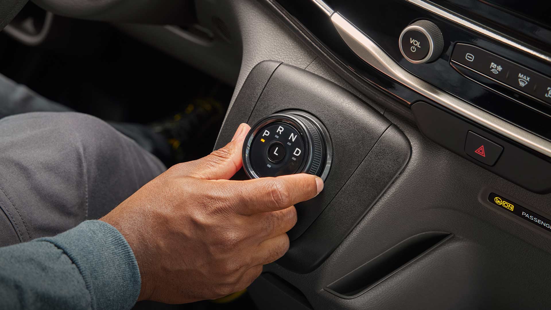 Close-up of a hand turning the gear selector knob in a Ford E-Transit electric van.