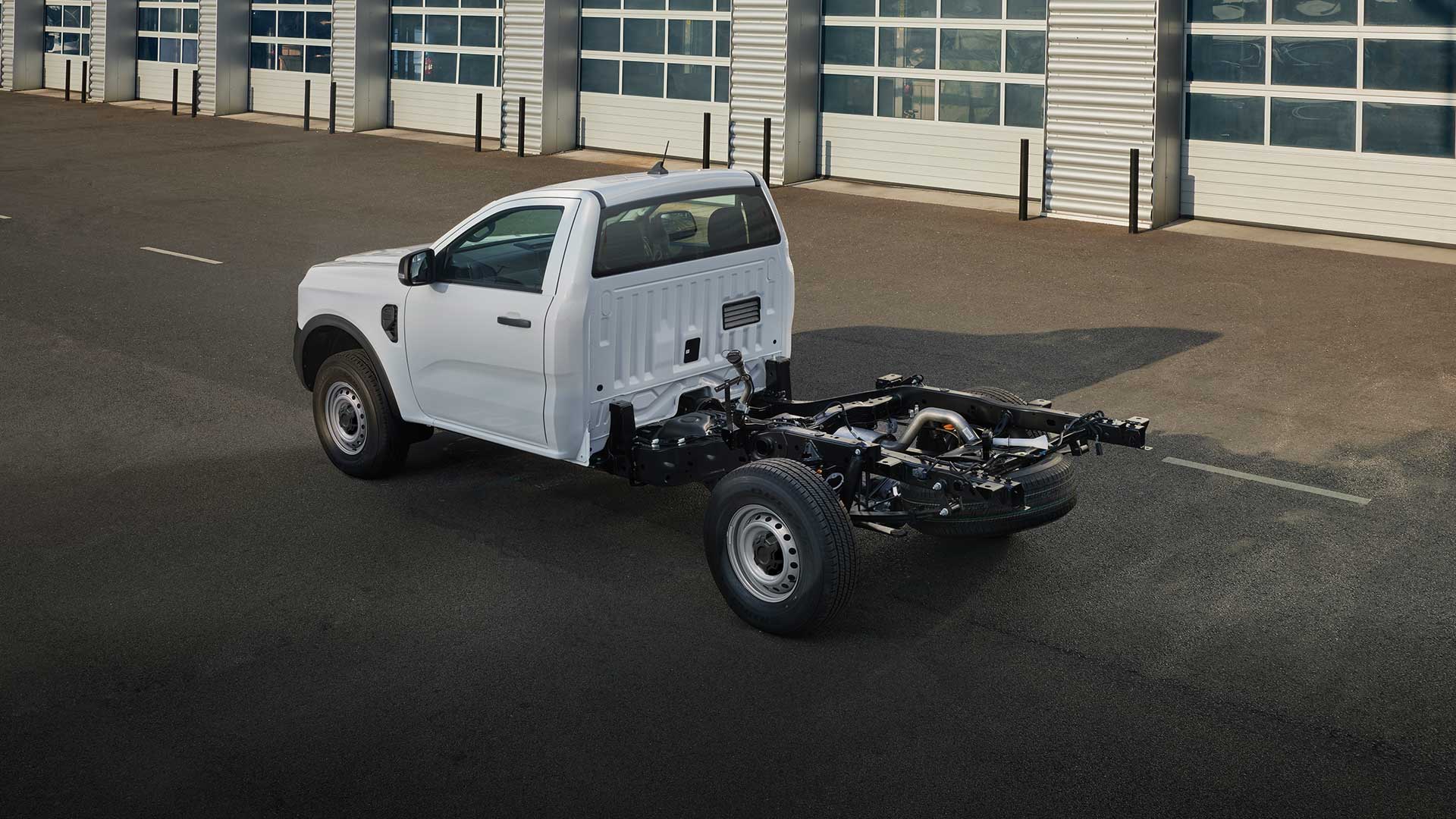 White Ford Ranger chassis cab, side view, showing the frame and exposed components.