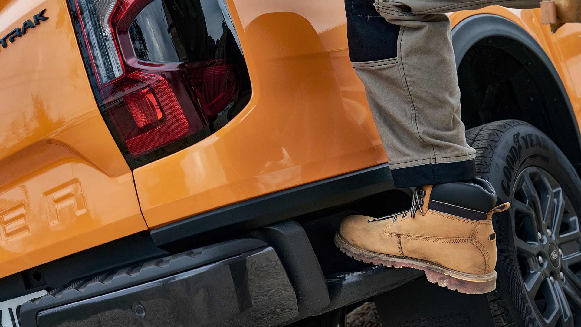 Worker stepping onto the integrated rear  step of the Ford Ranger.