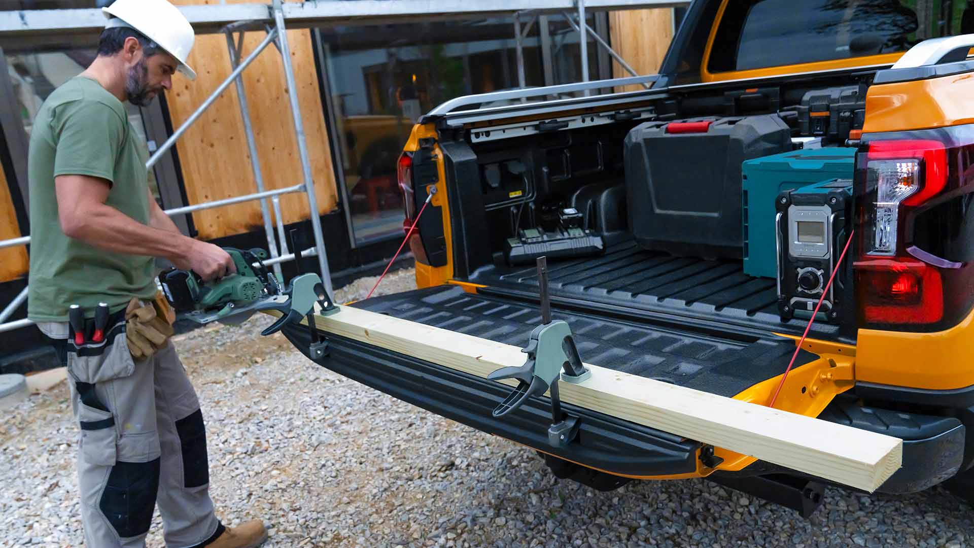 Worker using the tailgate of the Ford Ranger Wildtrak as a workbench.