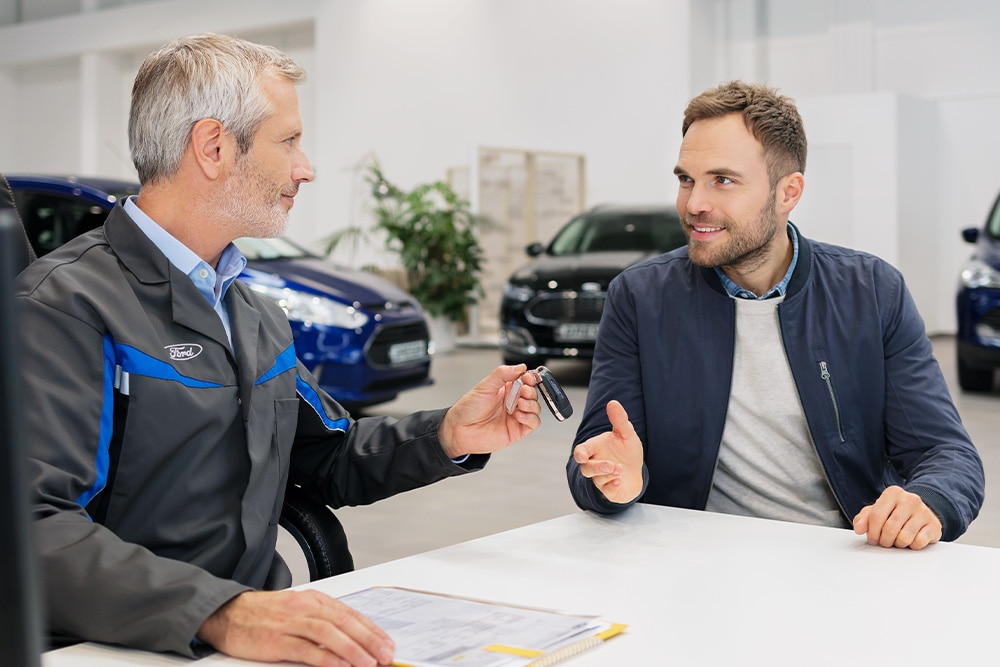 Two people discussing at Ford dealership