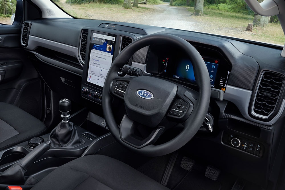 Interior view of the Ford Ranger, showing the steering wheel, dashboard, and gear stick.
