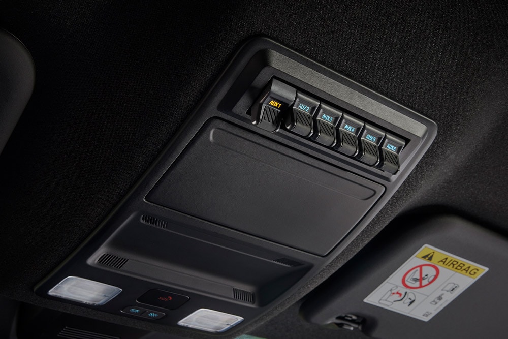 Close-up of hands connecting cables to the power outlet in thetruck bed of the Ford Ranger.