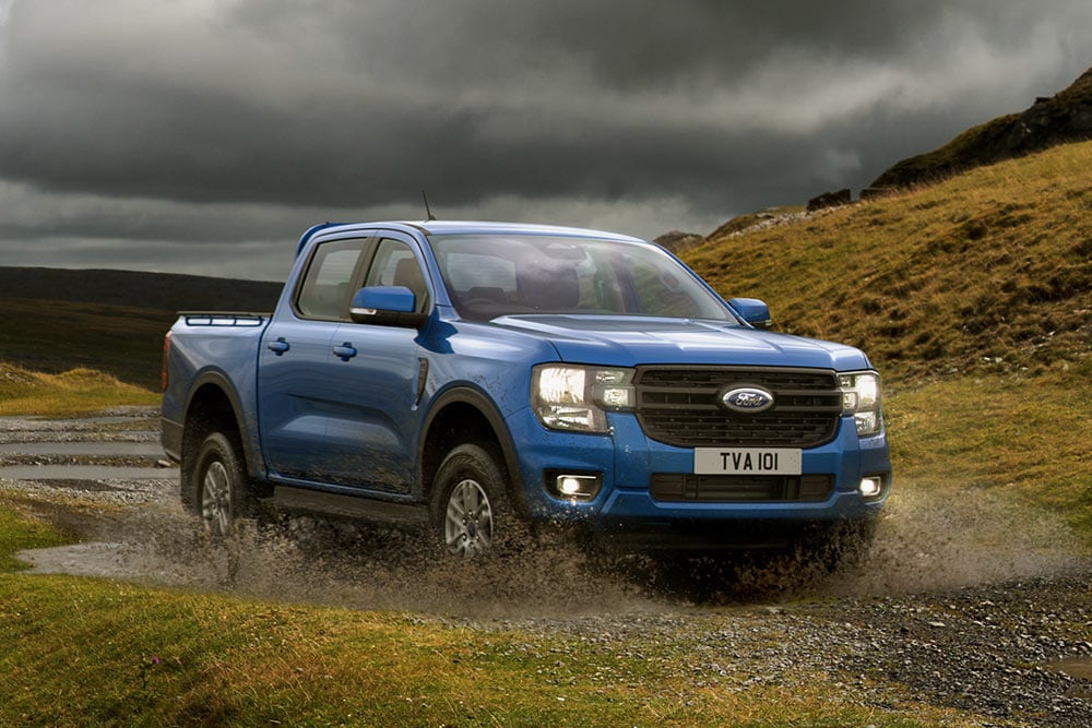 Blue Ford Ranger wading in a rugged landscape.