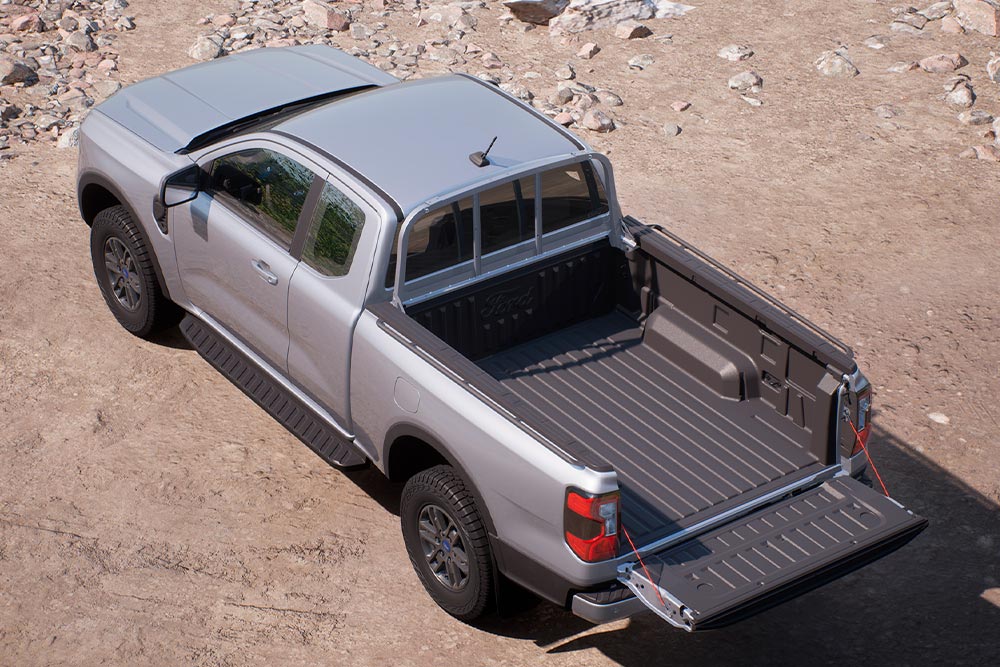 Silver Ford Ranger XLT  Super Cab parked on a sandy surface with tailgate open, viewed from above.