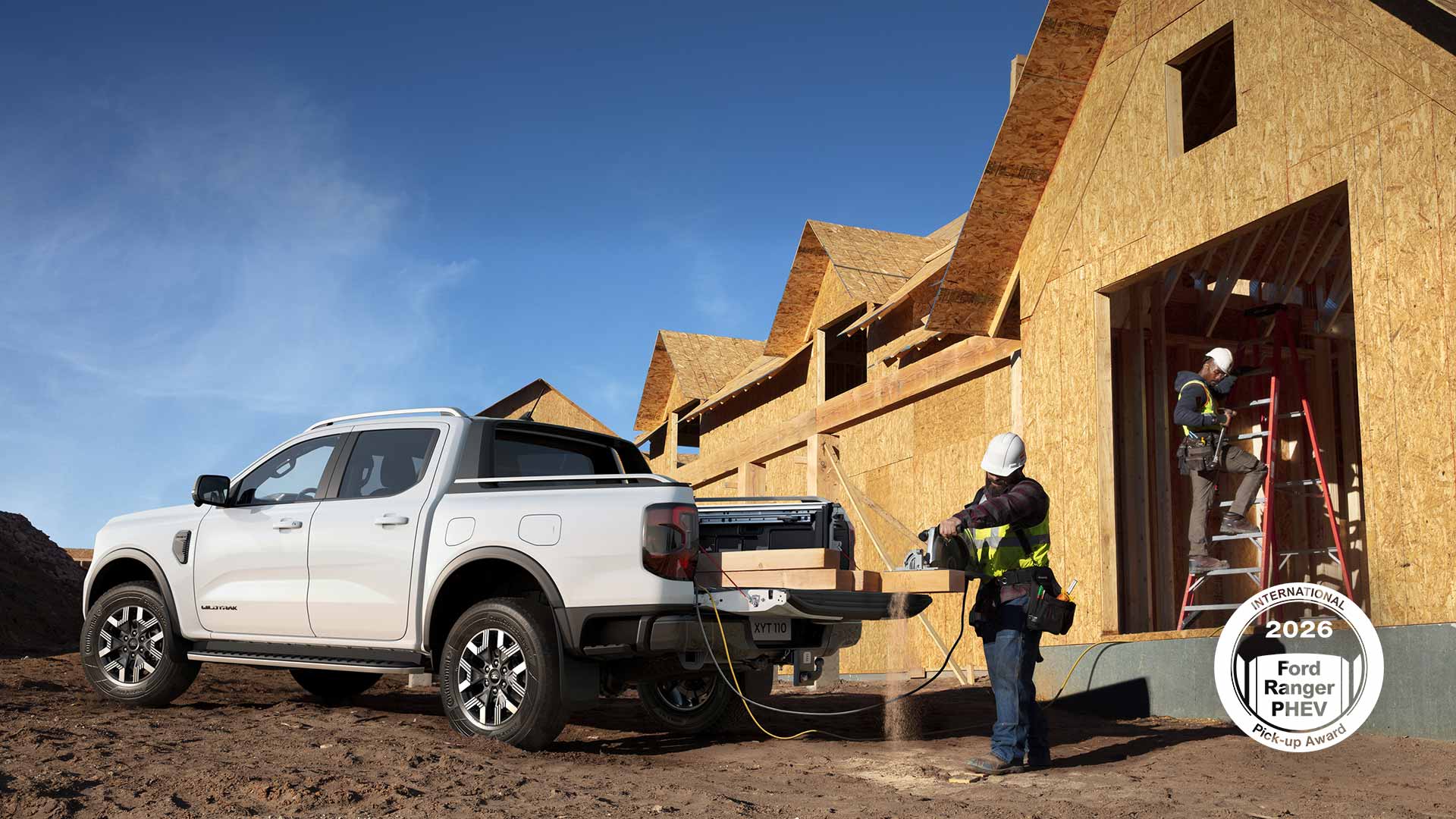 White Ford pick-up parked at a building site, powering a saw as a construction worker cuts wood.