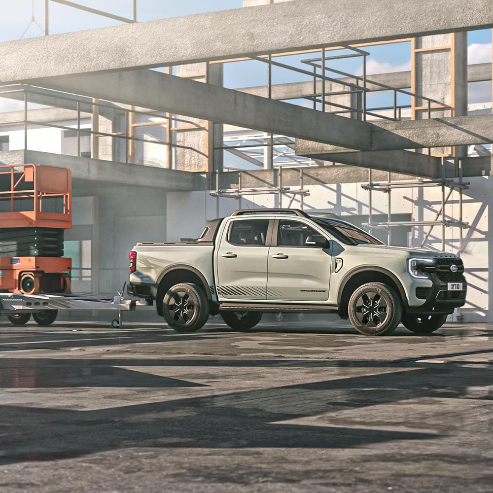 A yellow Ford Ranger drives down a country road.