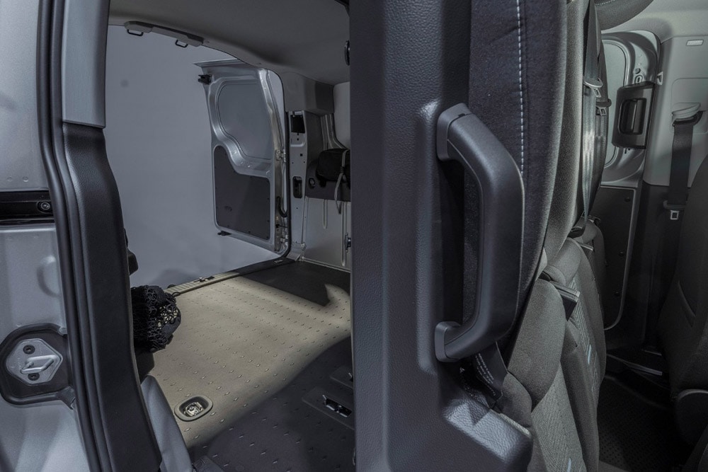 Interior of a Ford Transit Connect FlexCab showing folded rear seats and empty cargo area.