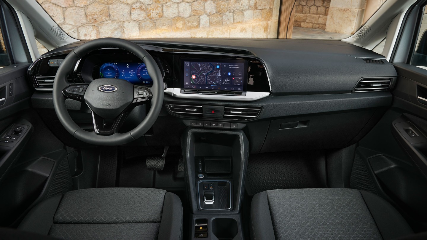 Front interior of All-New Ford Transit Connect showing steering wheel, digital instrument cluster and 10” touchscreen. 