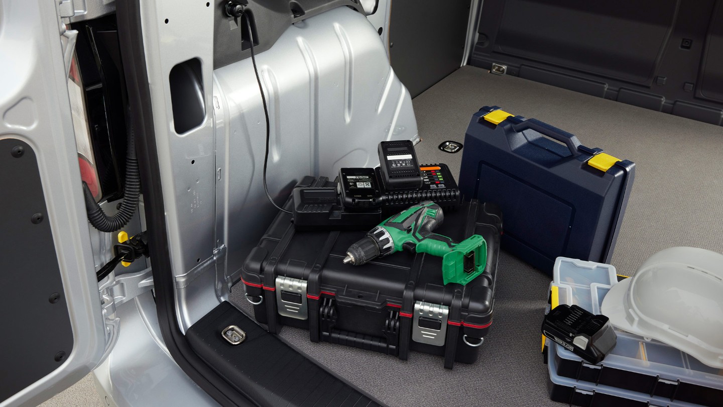 A power drill is plugged into a 12V socket in the load compartment of Ford Transit Connect.