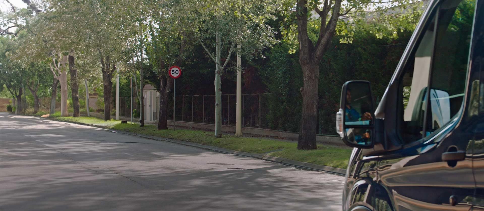 Ford Transit Van driving on a tree-lined road.