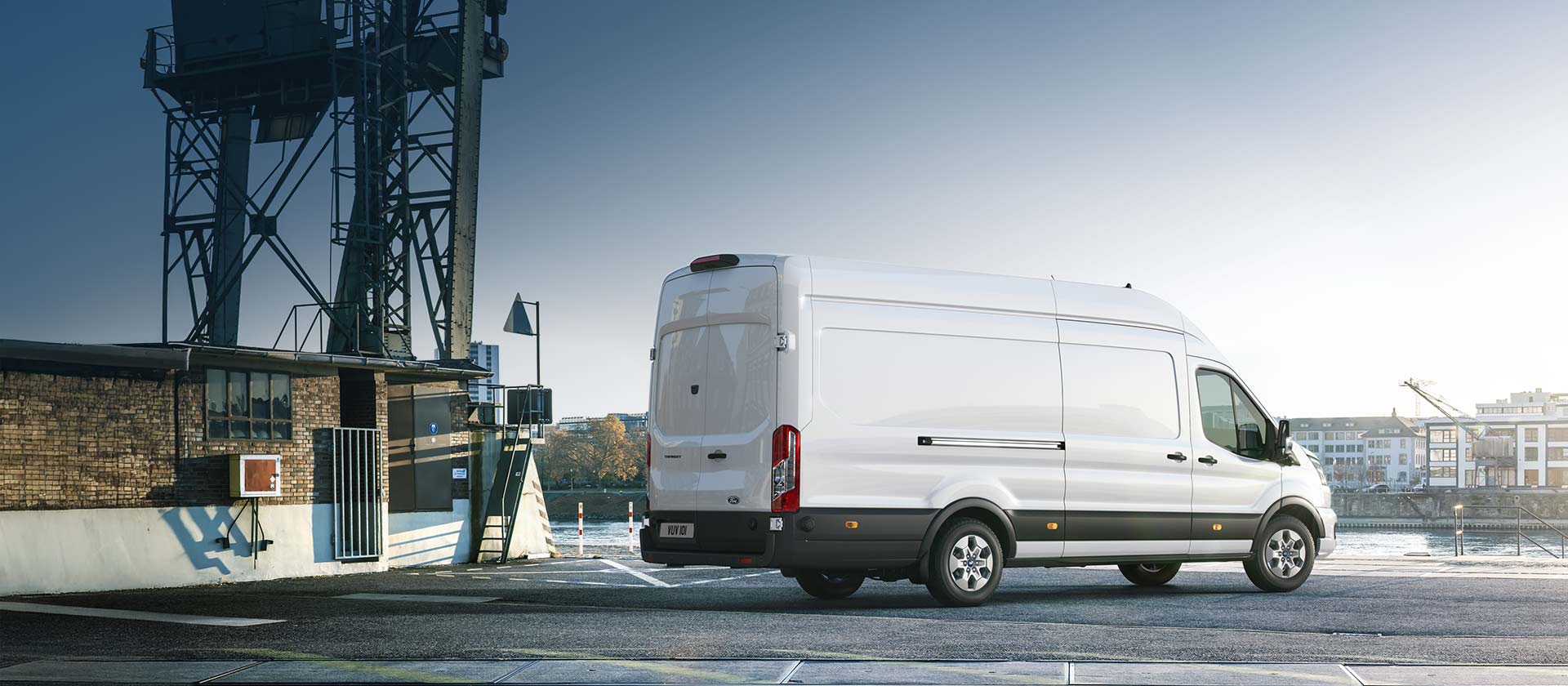 Side rear view of a white Ford Transit Van parked in a car park.