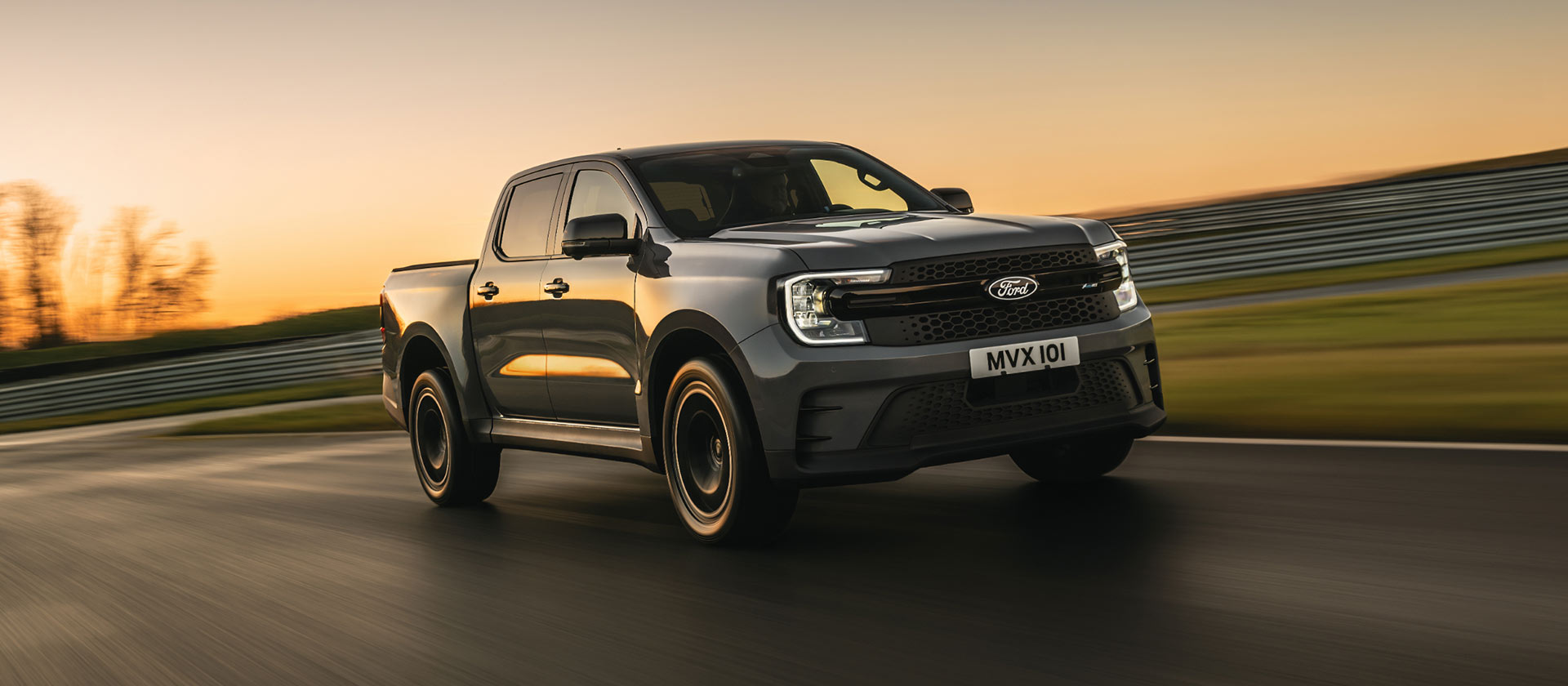 A grey Ford Ranger MS-RT driving along a track at sunset.