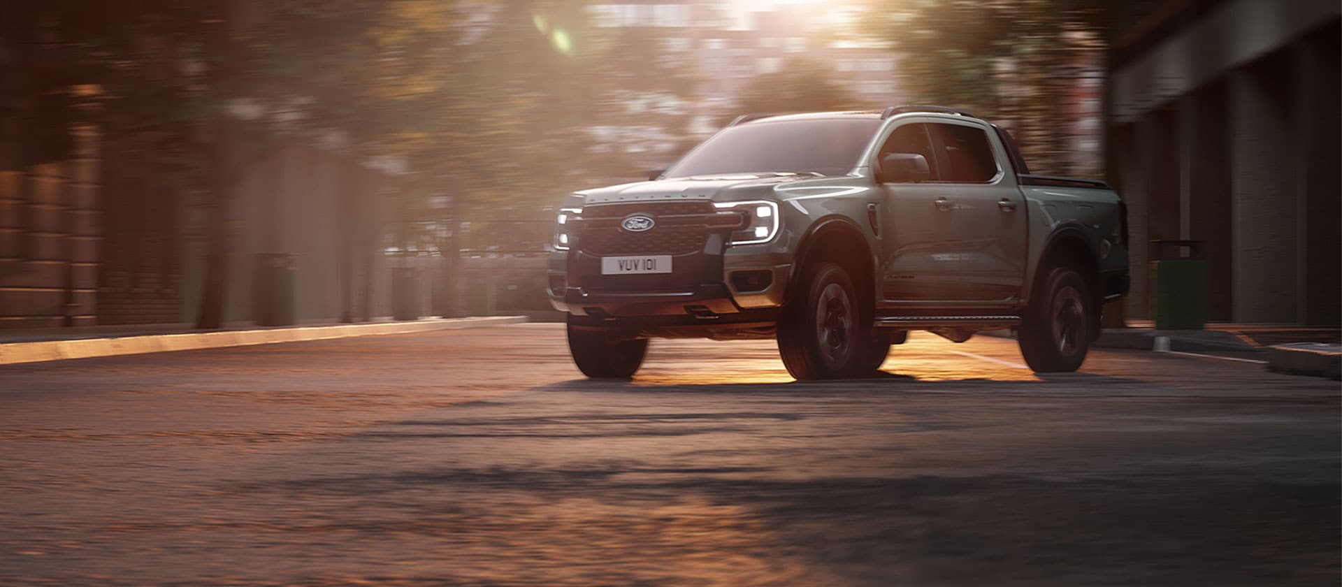 Ford Ranger PHEV driving through a city street at sunset.