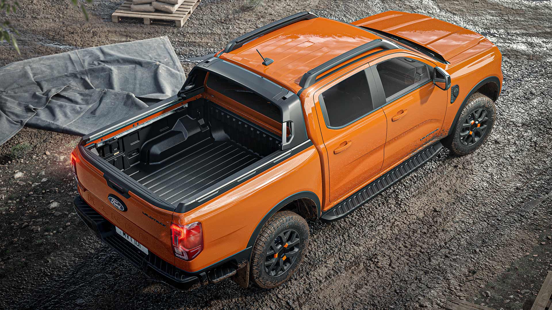 Top view of an orange Ranger Wildtrak X Double Cab parked on a muddy construction site.