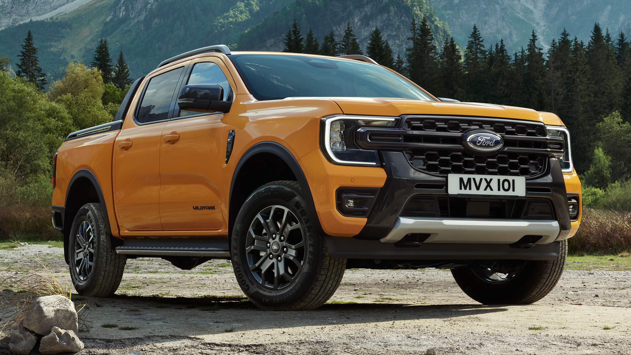 All-New Ranger in blue driving down forest road rear 3/4 view