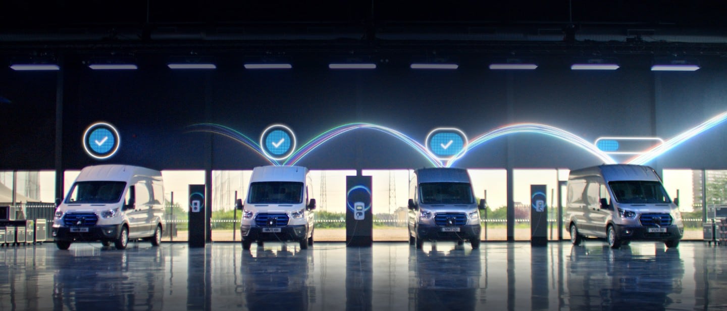 Two ford commercial vehicles driving through a city road