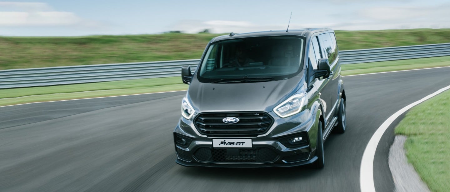 Red Ford Transit Custom MS-RT driving past a hill