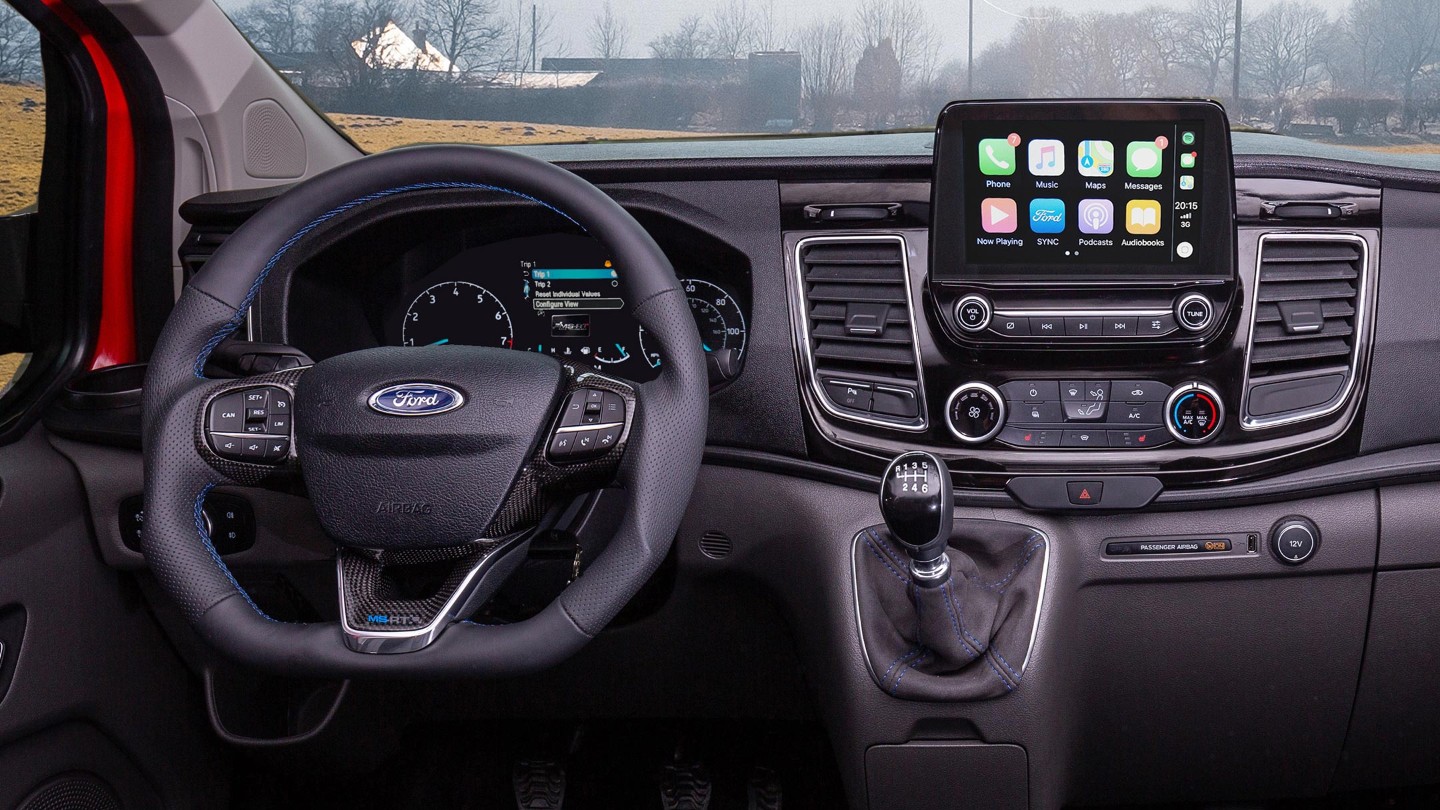 Interior view of the Ford Transit Custom MS-RT cockpit showing the steering wheel and dashboard modules