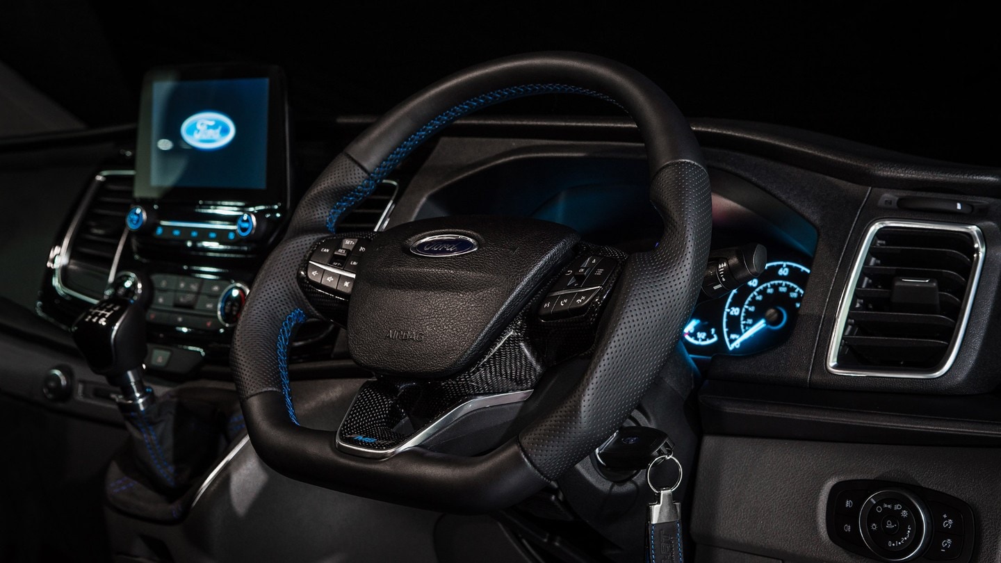 Closeup view of a Ford Transit Custom MS-RT cockpit, showing the steering wheel and dashboard modules