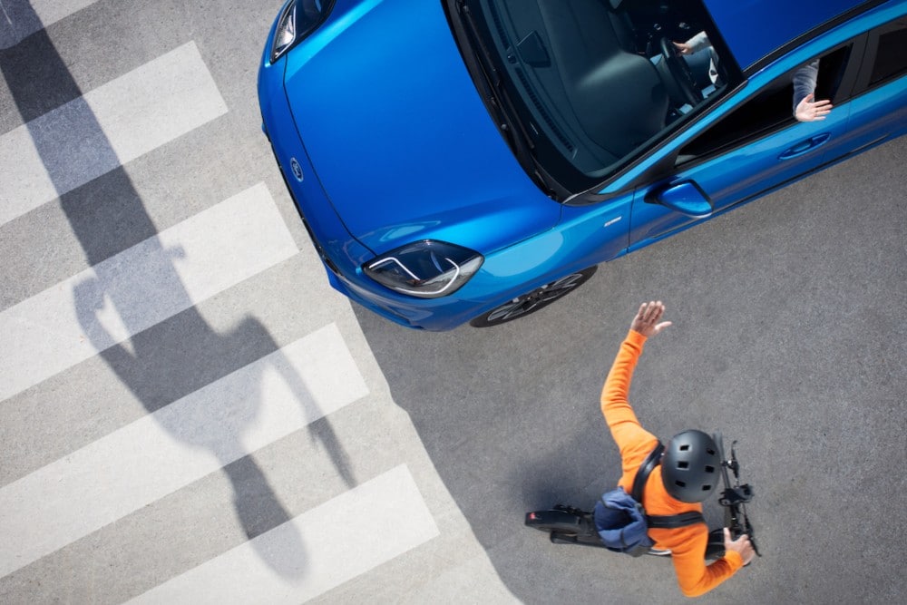 cyclist waving at car