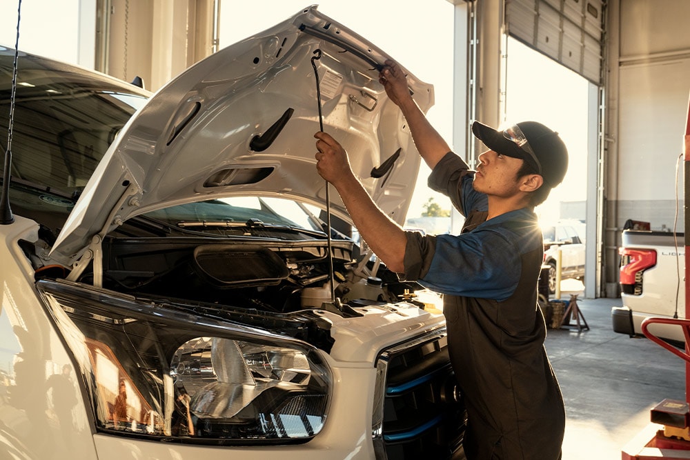Ford mechanic inspecting van bonnet in a garage.