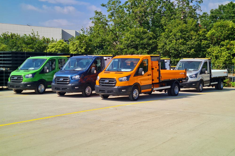 Different coloured Ford Pro Chassis Cabs parked in a sunny lot.
