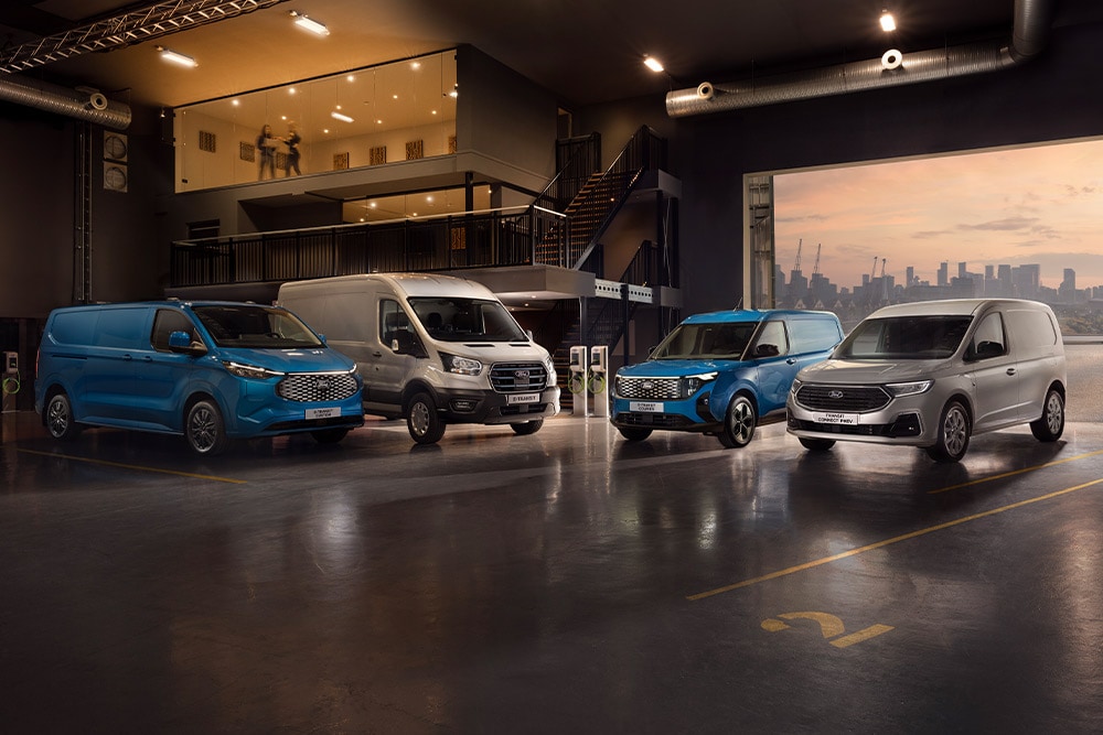 Fleet of Ford Transits in a showroom with a city skyline at dusk in the background.