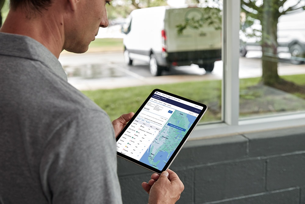 Man looking at his Ford vehicle data on a tablet, monitoring it live.
