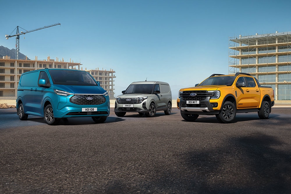 A collection of Ford vehicles parked in front of a construction site.