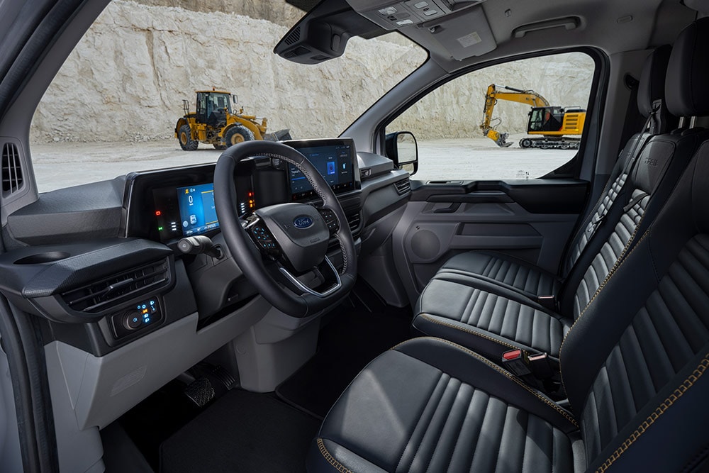  Interior view of a Ford Transit Custom van, showing the dashboard, steering wheel, and seats.