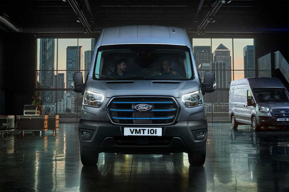 A silver Ford Transit van parked indoors alongside another van, representing commercial vehicle insurance.