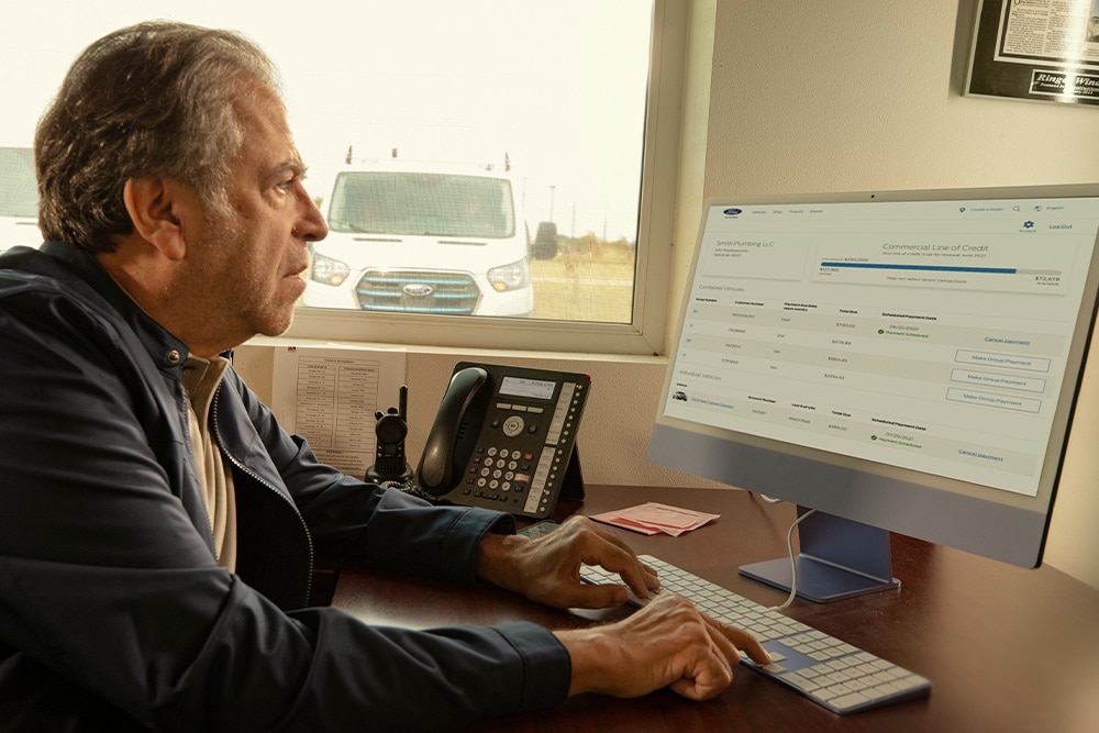 Man reviewing his Ford fleet data on a desktop computer.